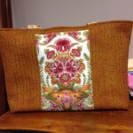 A brown and floral-patterned fabric tote bag on a wooden surface.