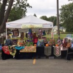 Creative Craftworks vendor tent with fabric totes, purses and table runners displayed