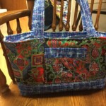 Colorful fabric bag with red, green, and blue patterns, resting on a wooden chair.