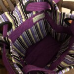 Purple and striped fabric bag with multiple pockets and a "Creative Crafter" label inside, placed on a wooden chair.