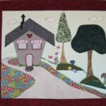 Fabric art of a house with trees, a path, butterflies, flowers, and a squirrel, set against a light background with clouds.
