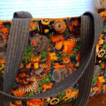 Colorful animal-patterned tote bag with gray handles, featuring lions, zebras, elephants, and other jungle animals.