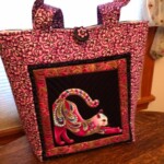 Pink patterned tote bag with a colorful, quilted cat design on the front.