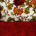 Floral-patterned fabric with red, yellow, and green leaves on white; below is a textured dark red fabric.