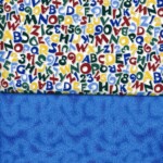 A colorful fabric with letters and numbers above a blue textured fabric background.