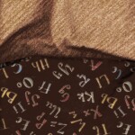 Alphabet-themed fabric with colorful letters on a dark background, draped over a textured brown surface.