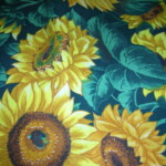 Pattern of vibrant yellow sunflowers with green leaves on a dark background.