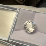 Round clear gemstone displayed in a gray padded box with an open lid at Creative Craftworks