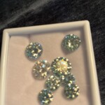 White tray holding eight round sparkling gemstones arranged on dark velvet at Creative Craftworks