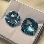 Two square faceted blue gemstones with intricate internal cuts on a white background at Creative Craftworks